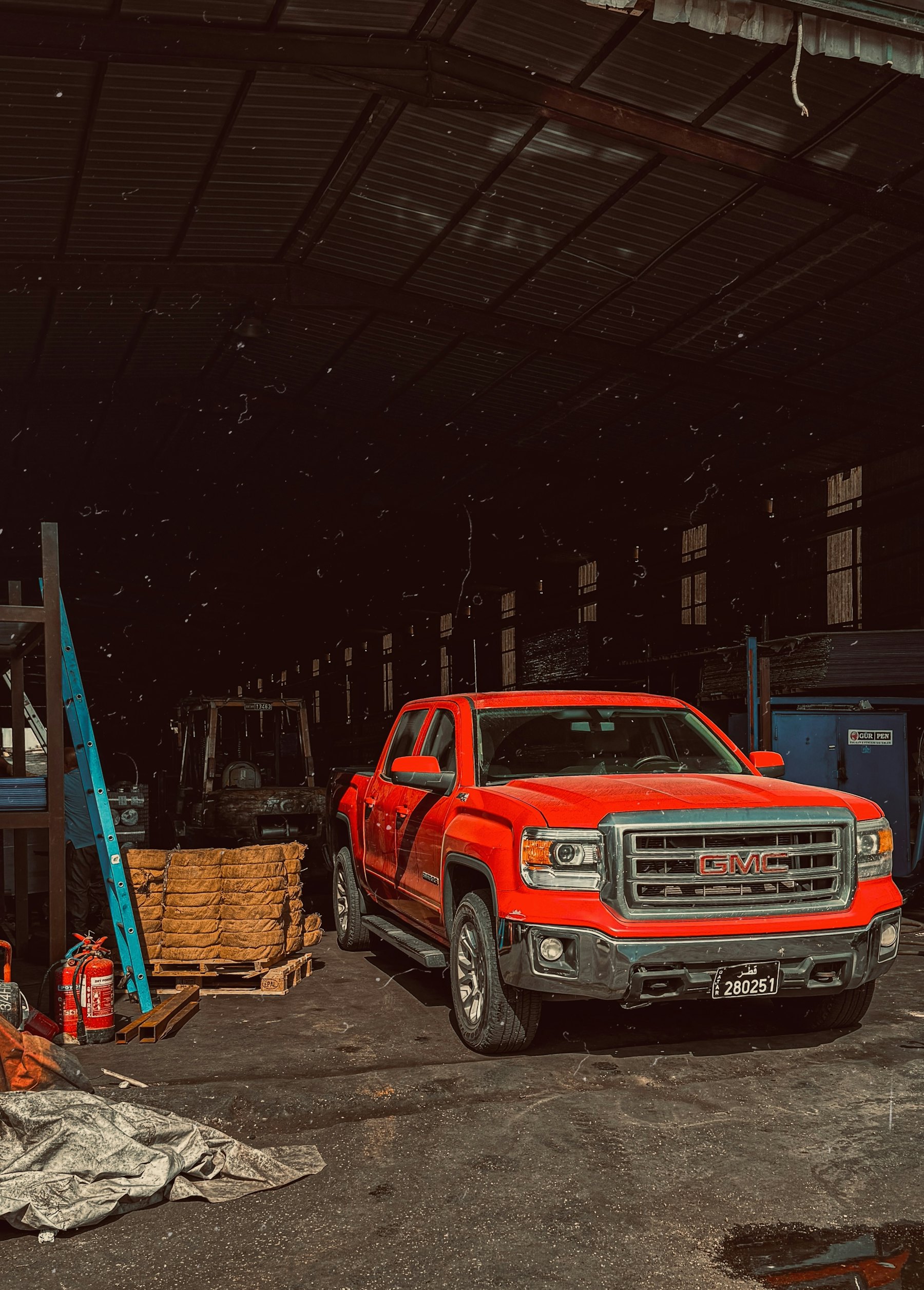 A red truck parked inside an industrial workshop